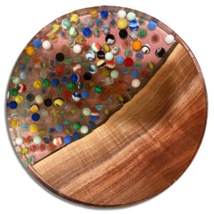 Round wooden and clear resin artwork with hundreds of colorful glass marbles embedded in the transparent section